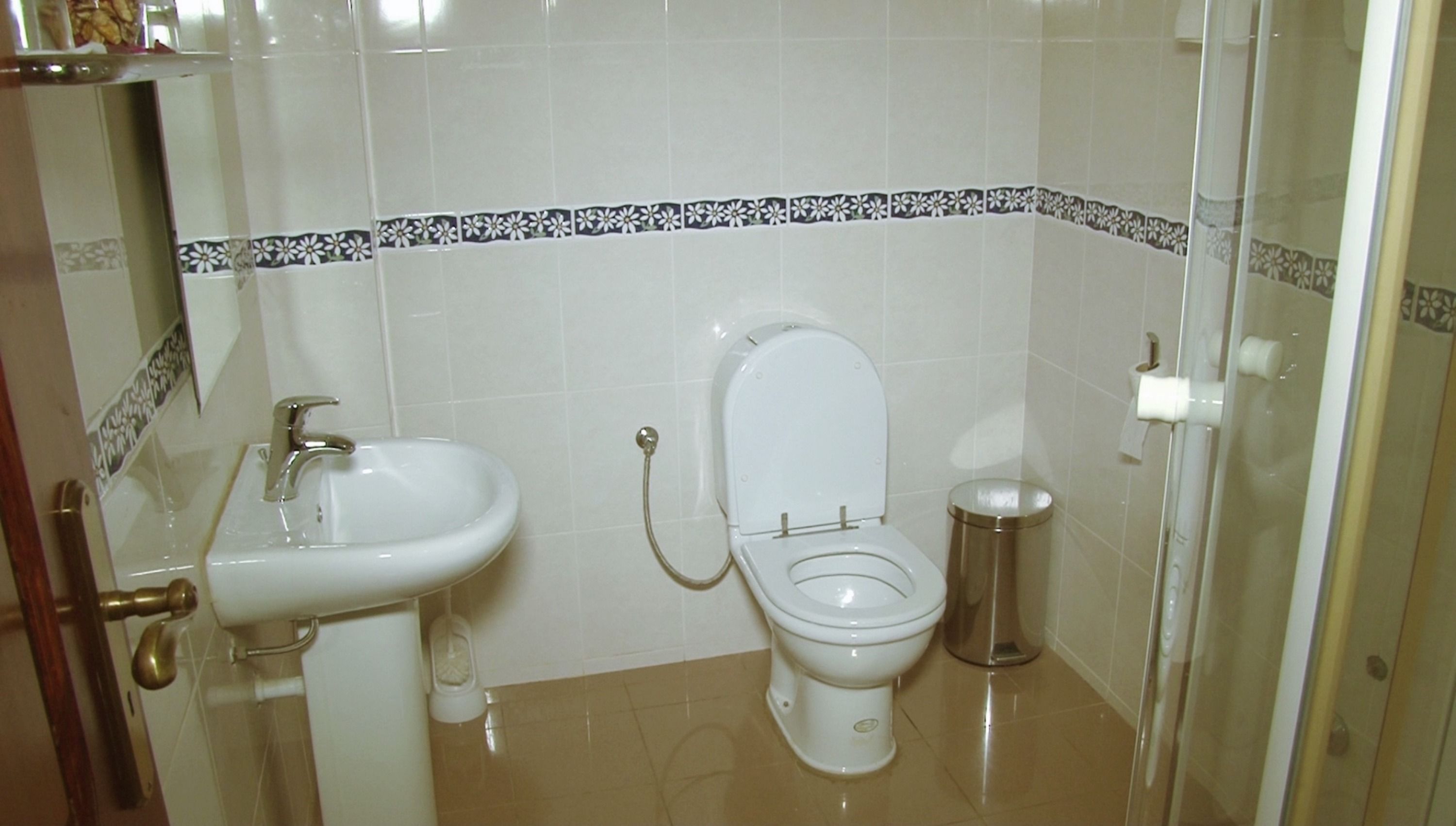 A bathroom with a toilet, sink, and bidet.