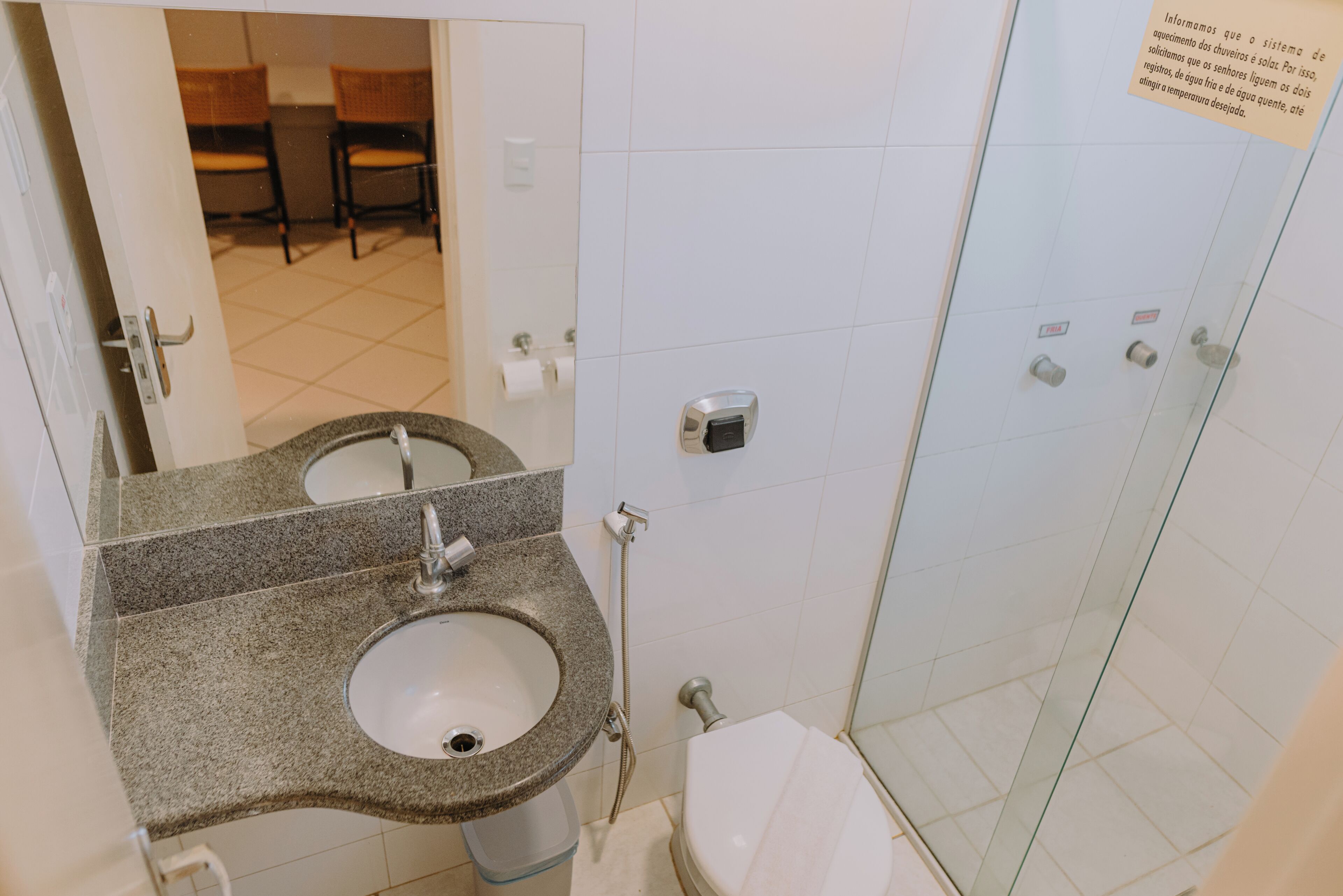 A bathroom with two sinks, a toilet, and a glass shower enclosure.