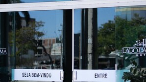 Entrada de hotel con puertas de vidrio y un letrero que dice "SEJA BEM-VINDO" y "ENTRE".
