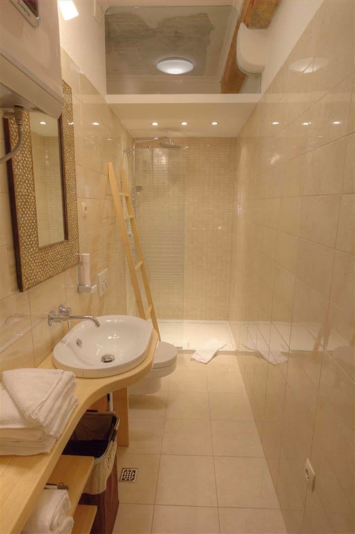 Une salle de bain avec un lavabo, un miroir et une douche.
