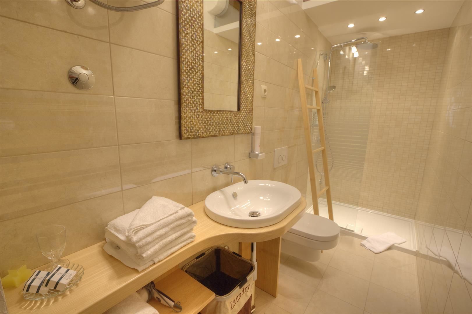 A modern bathroom with a sink, mirror, and shower.