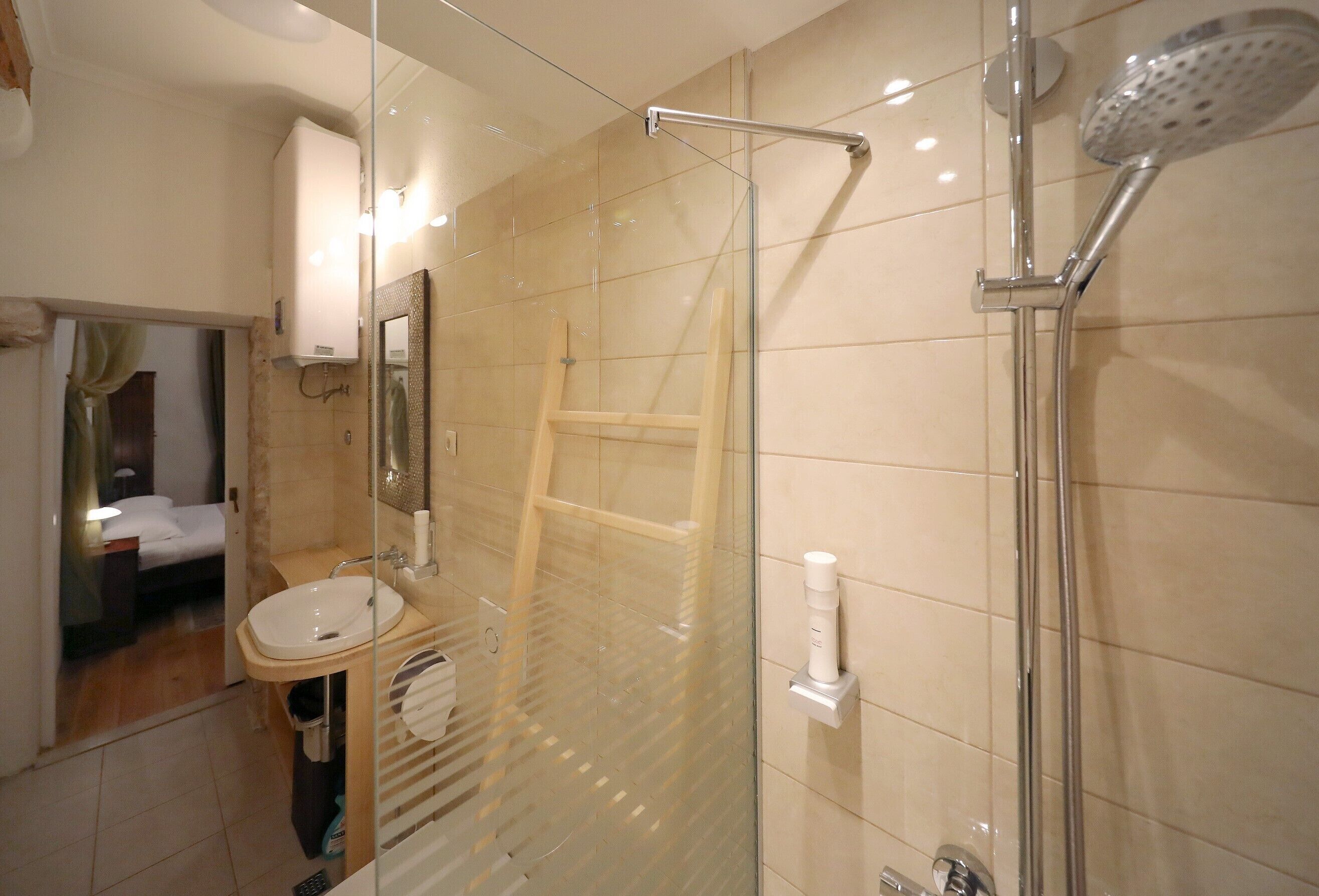 Un baño moderno con cabina de ducha de vidrio, un lavabo y un espejo.