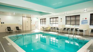 Una piscina interior con marcas claras para carriles, una zona poco profunda y una plataforma de salto.