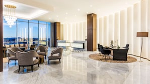 A modern lobby with a reception desk, seating area, and large windows offering a city view. - Hyatt Regency San Luis Potosi (San Luis Potosi)
