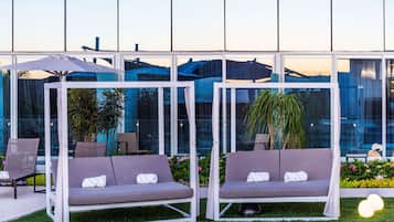 Alberca al aire libre, sombrillas en la alberca y camastros