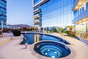 A modern hotel with a swimming pool, outdoor seating, and a view of the cityscape. - Hyatt Regency San Luis Potosi (San Luis Potosi)