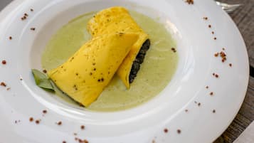 A white plate with a green sauce and two yellow items, possibly food, on a wooden table.