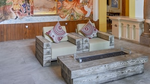 A lobby with a mural, wooden ceiling, and seating area with cushions. - Casona de los Sapos Hotel Boutique (Puebla)