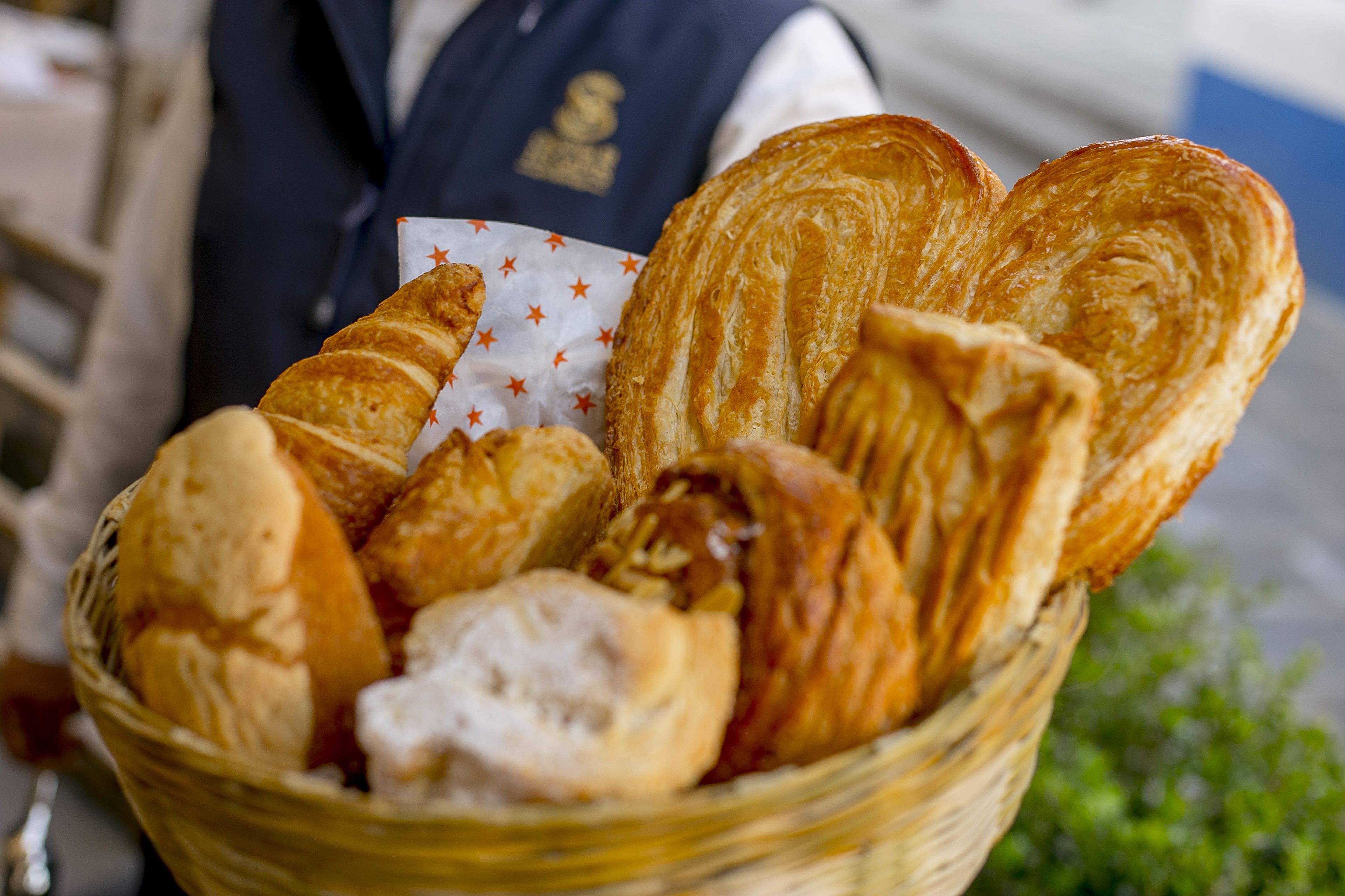 Una cesta con diferentes tipos de pan, como croissants y barras.