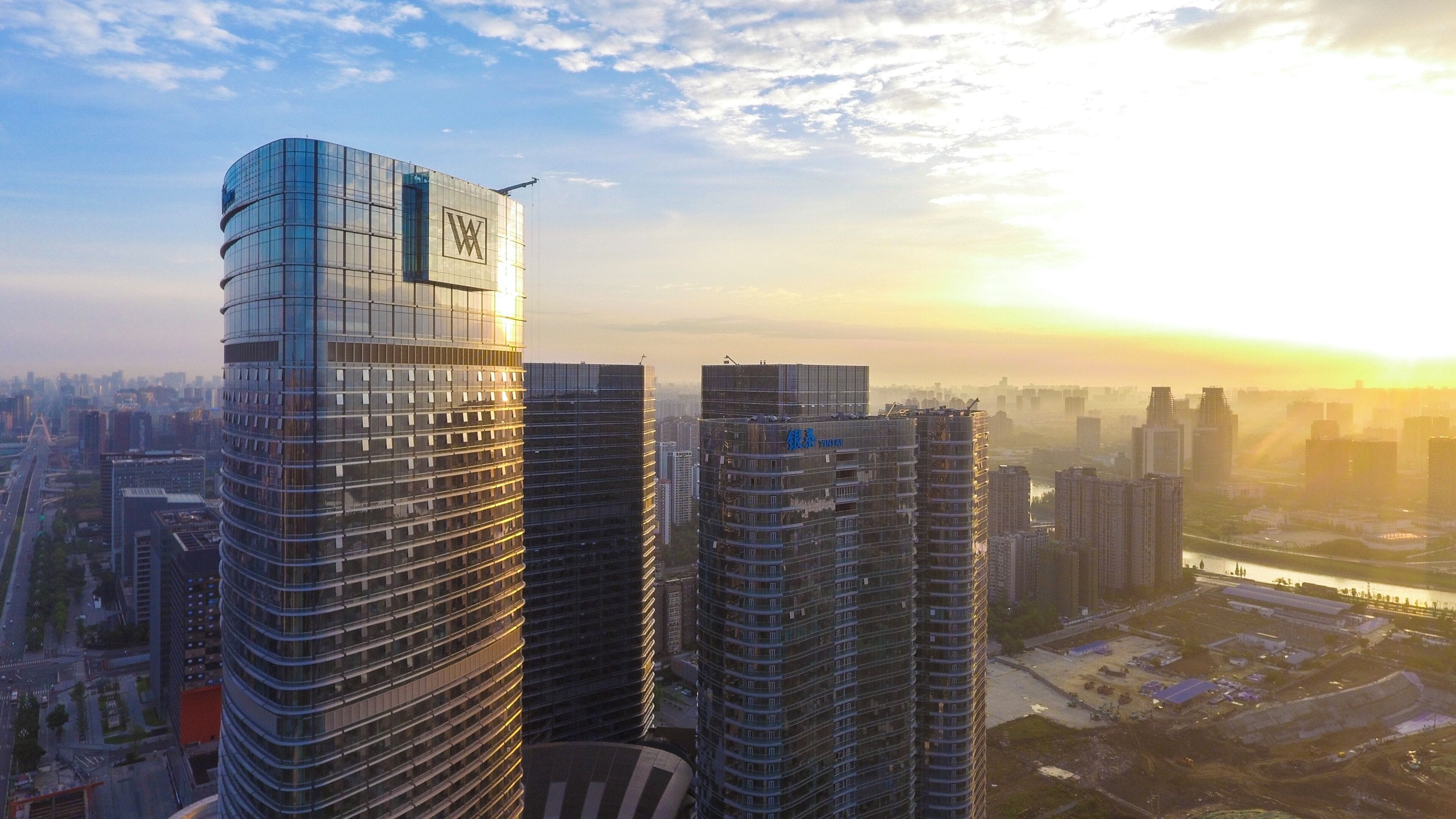 Um edifício alto com um topo curvado característico e um logotipo bem visível.