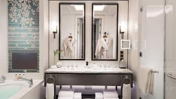 A modern bathroom with a double sink vanity, a large mirror, a bathtub, and a scale.