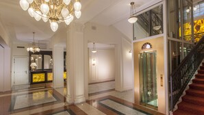 A grand lobby with a marble floor, a large chandelier, and a staircase leading to an upper level. - Luxury Spa Hotel OLYMPIC PALACE (Karlovy Vary)