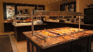 A buffet area with multiple food stations, a large stainless steel range hood, and a marble countertop. - Luxury Spa Hotel OLYMPIC PALACE (Karlovy Vary)