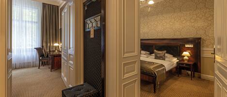 A hotel room with a large bed, bedside tables, a desk, and a chair.