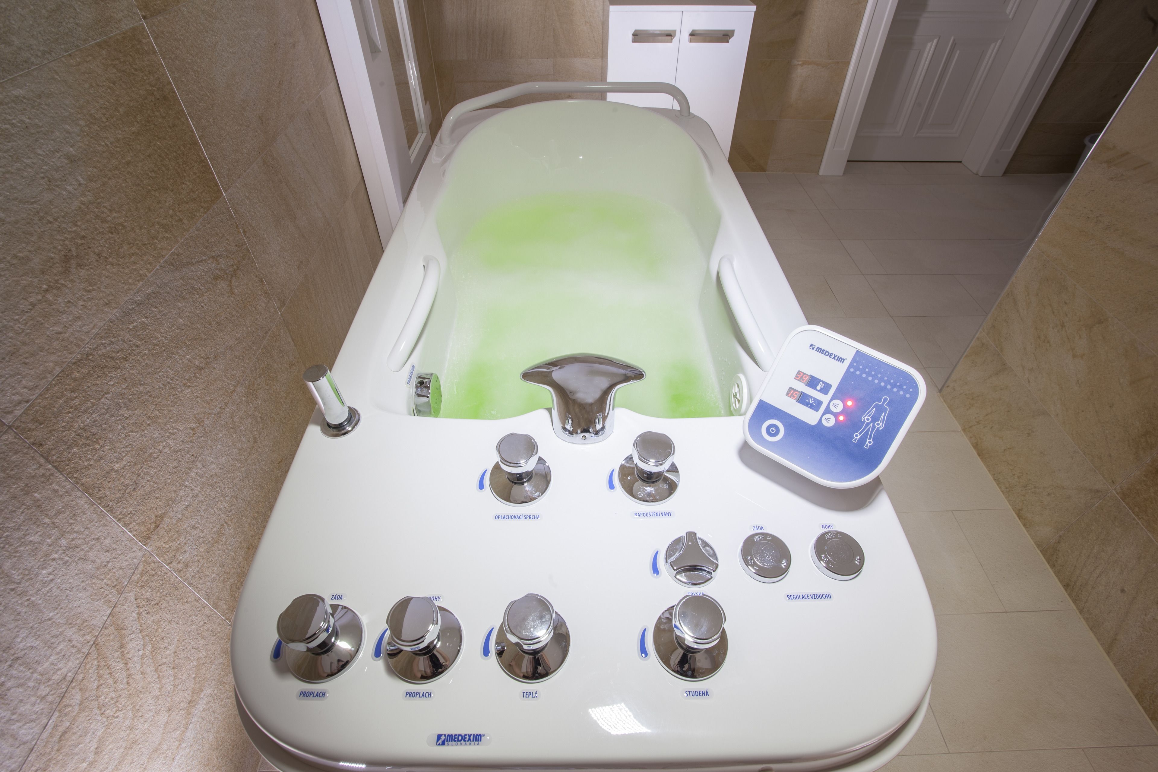 A modern bathtub with control knobs and a digital interface, likely for adjusting water temperature and flow.