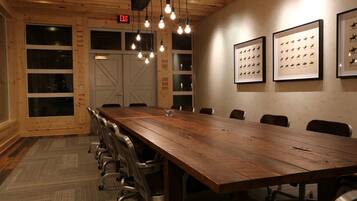 A conference room with a long wooden table, chairs, and framed horse silhouettes on the wall.