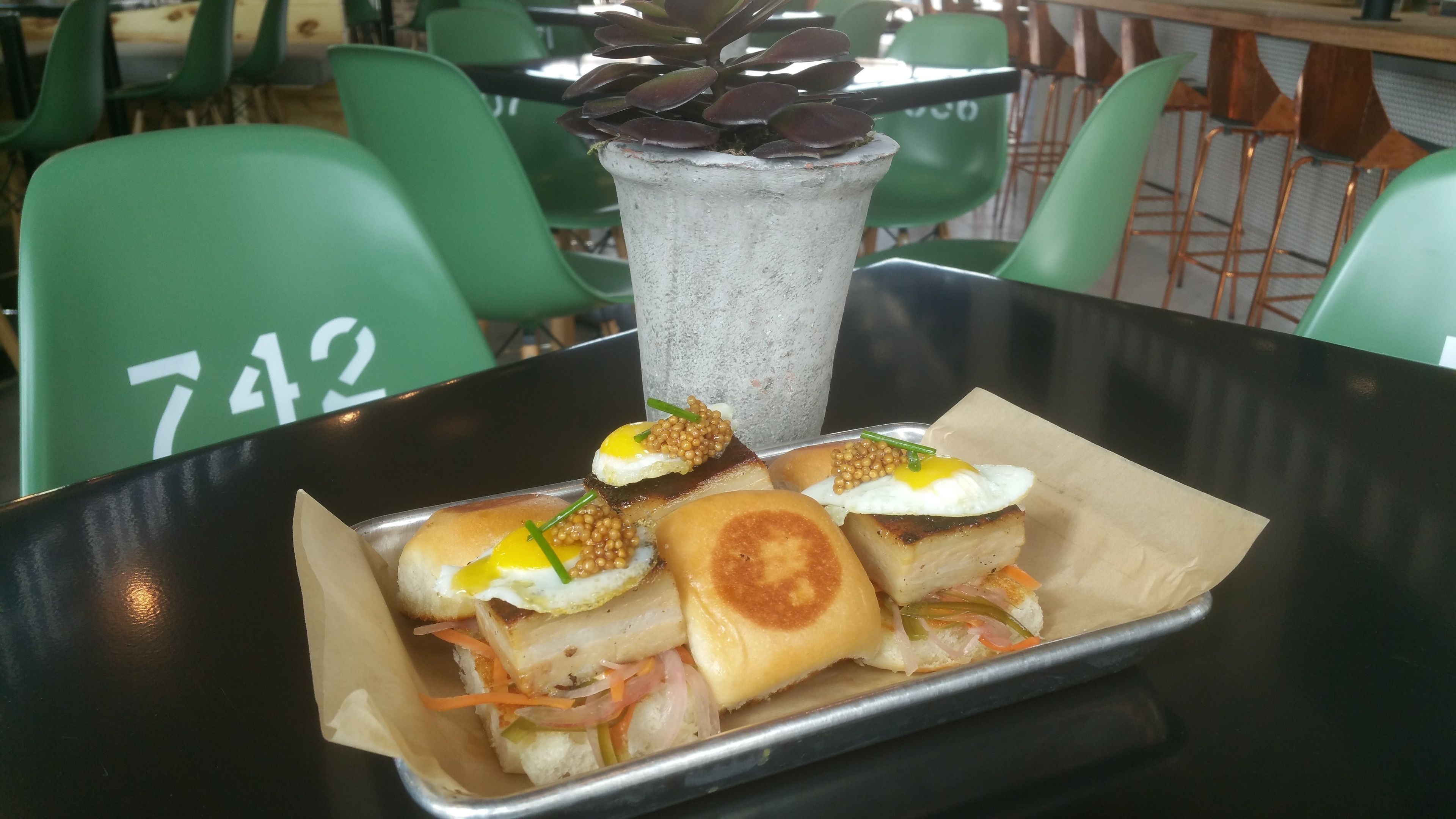 A tray with sandwiches and a drink in a restaurant setting.