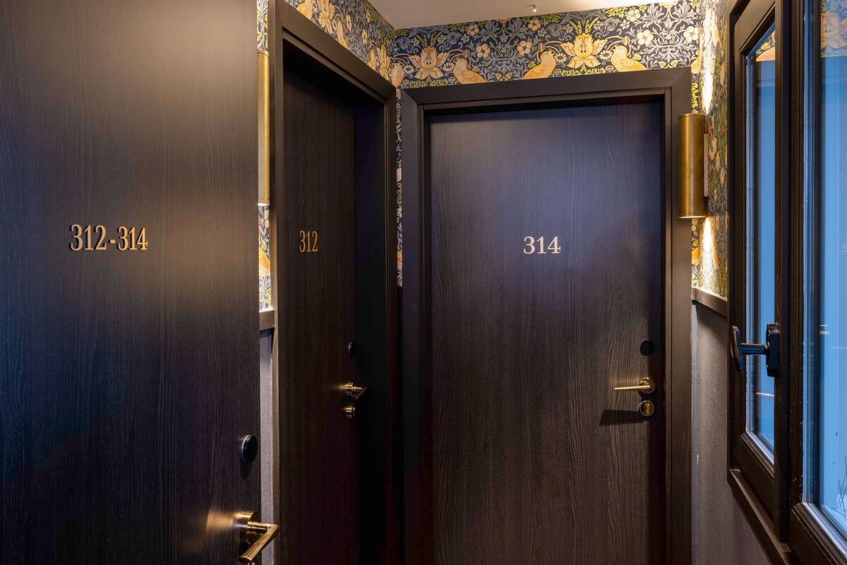 Two dark wooden doors with room numbers 312 and 314.