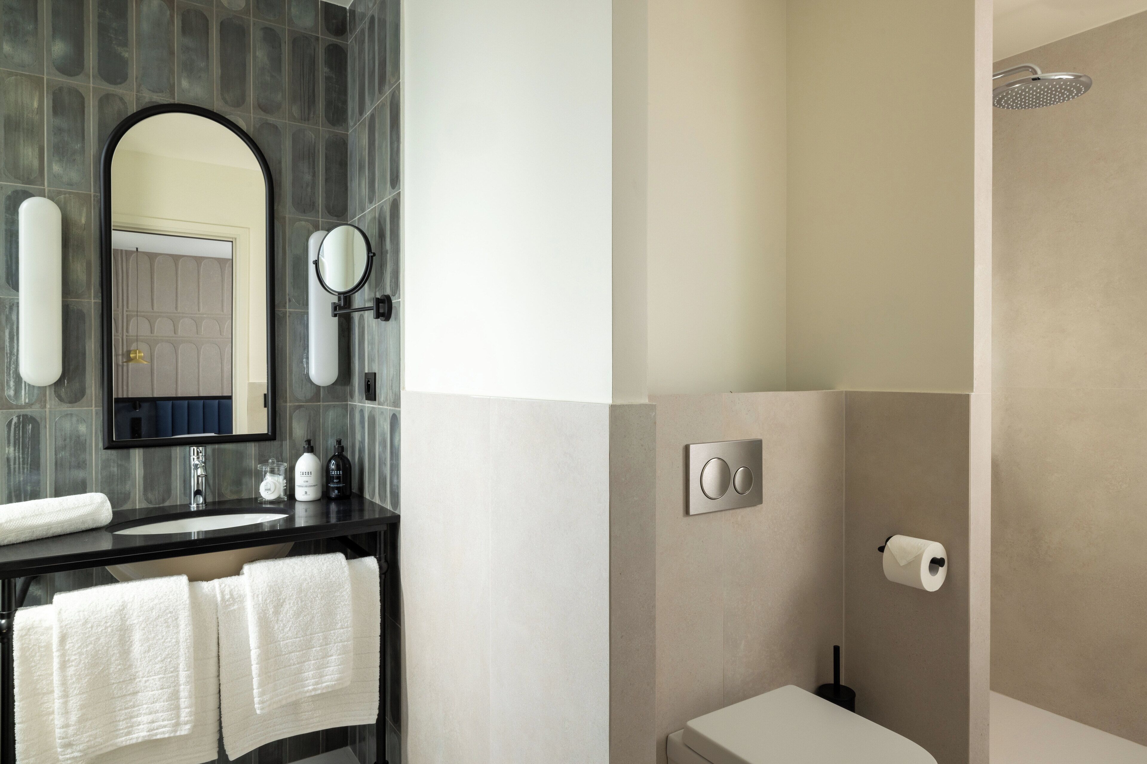 A modern bathroom with a vanity, mirror, and shower.