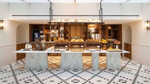 A buffet setup with marble tables and a variety of food items.