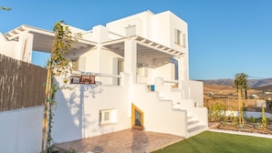 A modern white house with a flat roof, a small front porch, and a paved patio. - Naxian Resort (Naxos)