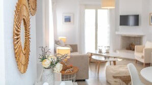 A modern living room with a sofa, a coffee table, and a TV mounted on the wall. - Naxian Resort (Naxos)
