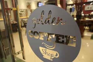 A circular sign with the words "golden coffee shop" and a coffee cup icon. - Hotel Roditha (Banjarmasin)