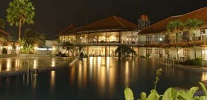 A hotel with a swimming pool, multiple guest rooms, and a well-lit outdoor area. - Horison Tirta Sanita Kuningan (Cilimus)