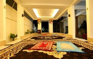 A corridor with a carpeted floor, a central door, and a view into another room. - Hotel Grand Permata Hati (Banda Aceh)
