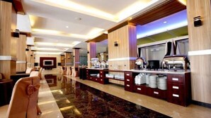 Un amplio vestíbulo de hotel con una larga recepción, asientos cómodos y un diseño moderno.