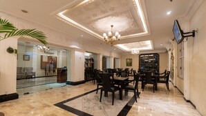 A spacious lobby with a marble floor, a chandelier, and a television mounted on the wall. - D'Salvatore Art & Boutique Hotel (Depok)