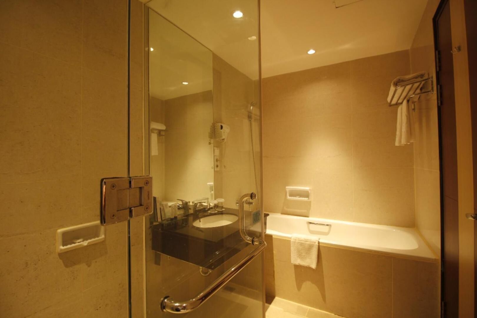 A modern bathroom with a glass shower enclosure, a sink, and a towel rack.