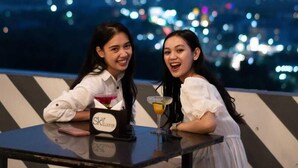 Two people seated at a table with a cityscape view in the background. - Claro Kendari (Kendari)