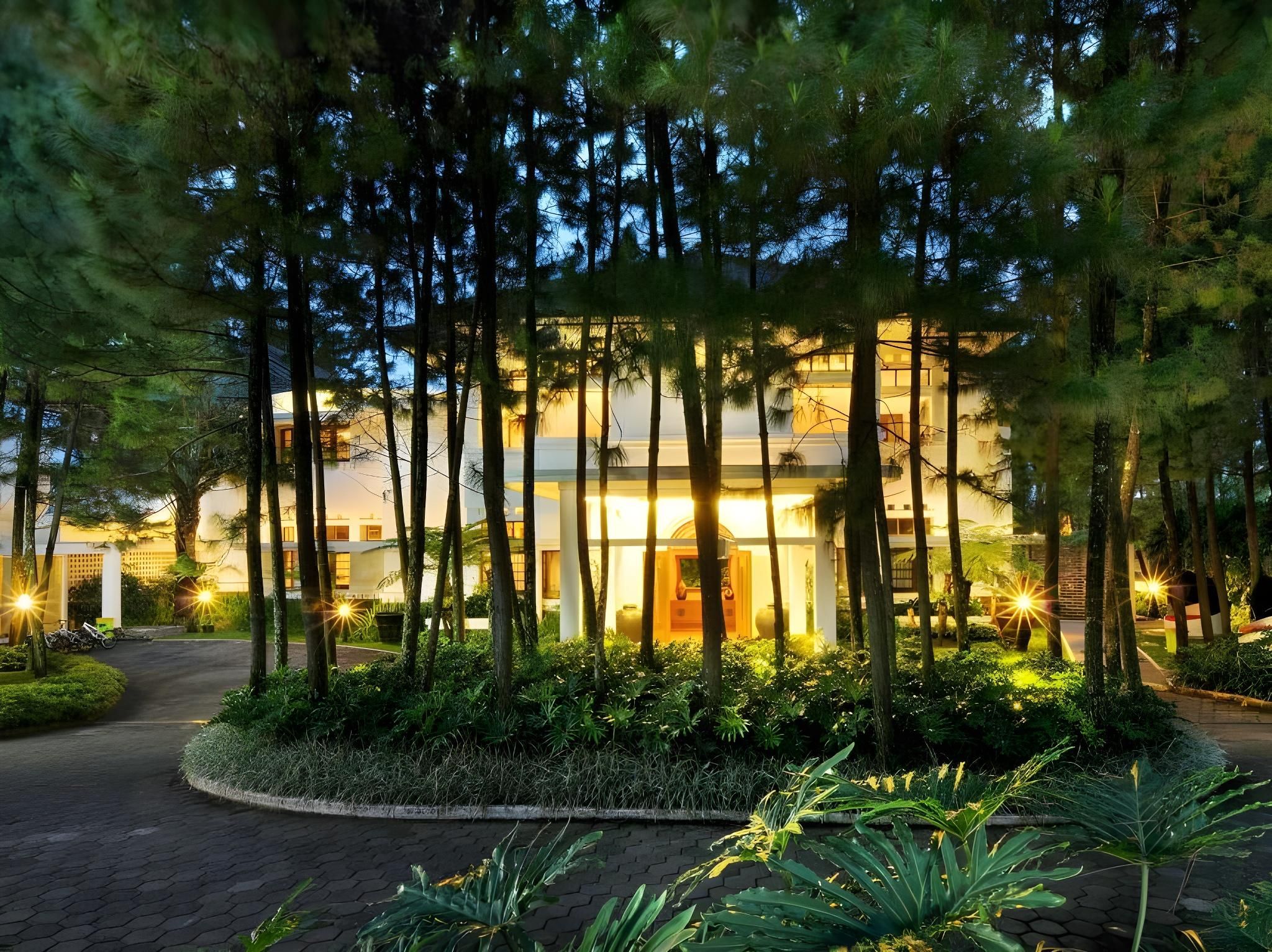 A modern building with a well-maintained garden and a paved driveway.