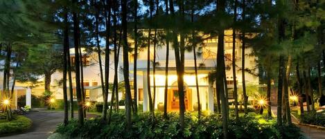 A modern building with a well-maintained garden and a paved driveway.