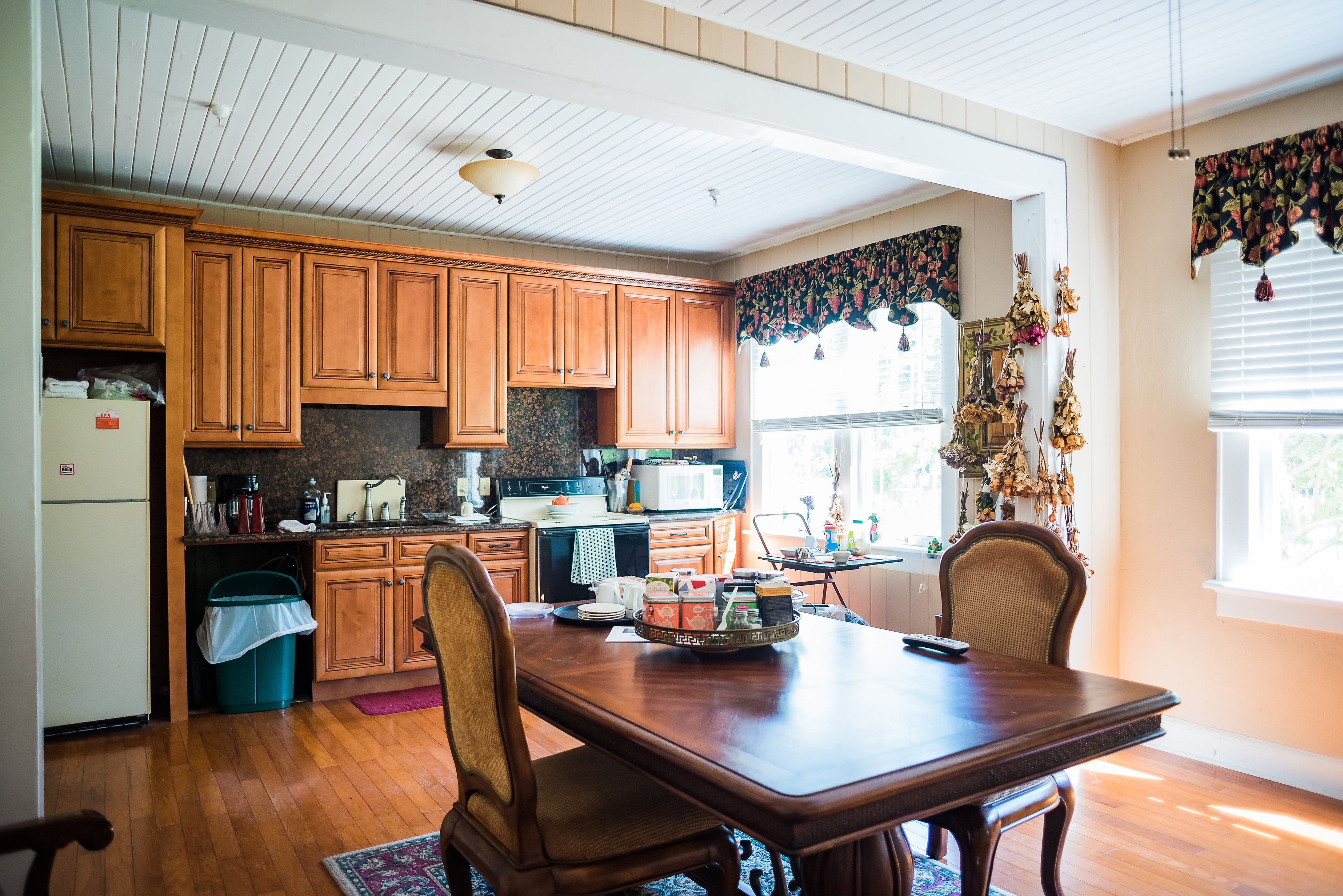 A spacious kitchen with wooden cabinets, a dining table, and chairs.