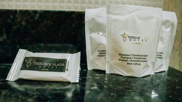 Taulell de bany amb productes de tocador de l'Hotel Trindade Plaza, incloent bosses de xampú i condicionador.