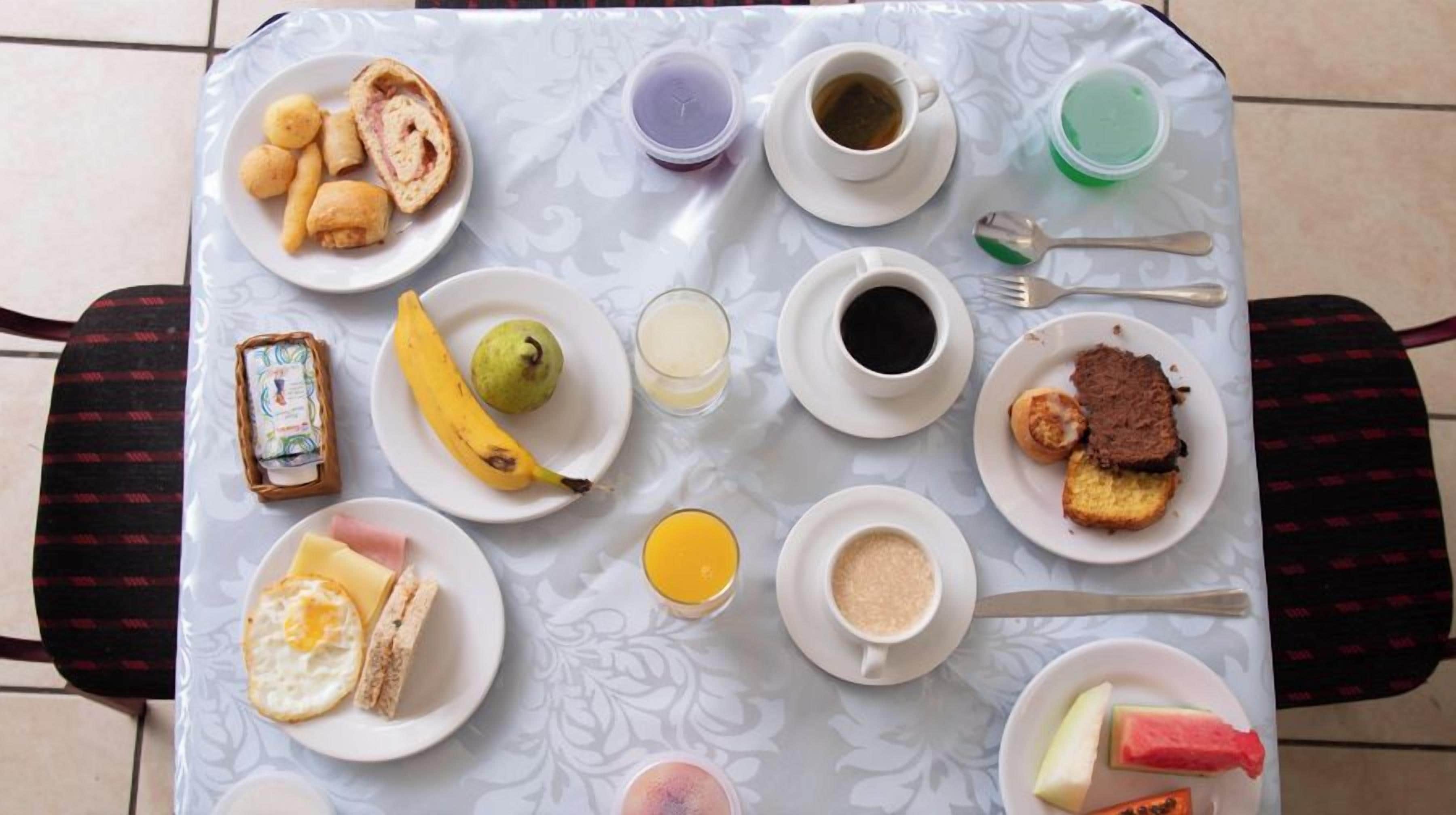 A breakfast table with various food items and drinks.