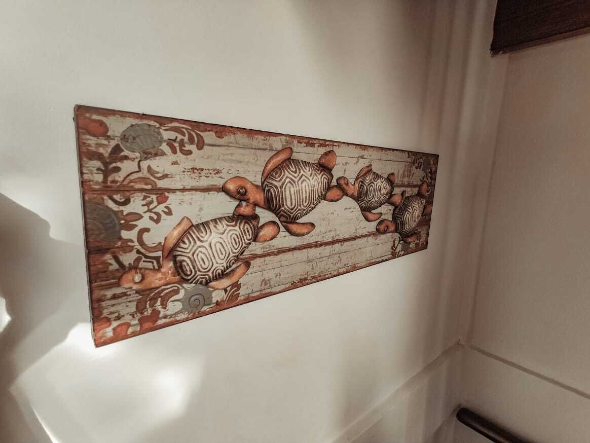 Una pared con un panel decorativo que muestra un diseño de tortugas.