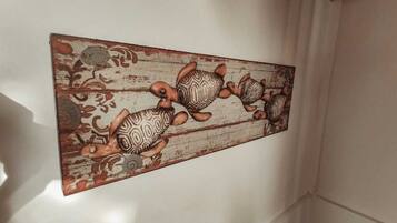 Una pared con un panel decorativo que muestra un diseño de tortugas.