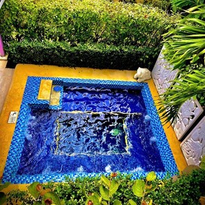A small, square-shaped pool with a blue mosaic border and a central water feature. - Summer House Inn San Andres (San Andrés)