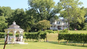A gazebo and a large house surrounded by lush greenery. - Orchard House B&B (Lovingston)