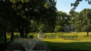 A fountain in a park with a gazebo and a large house in the background. - Orchard House B&B (Lovingston)