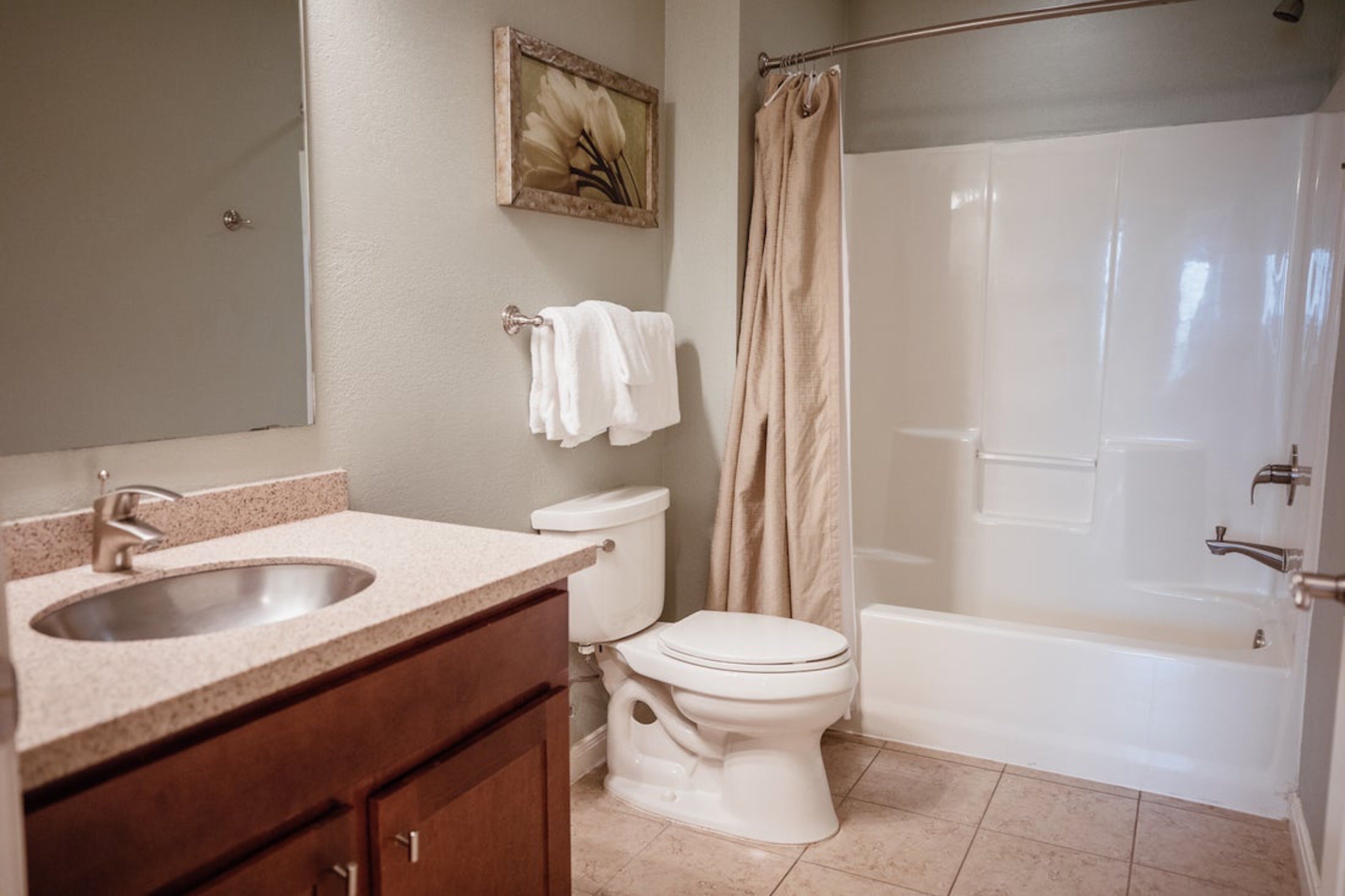 A bathroom with a sink, toilet, and bathtub.
