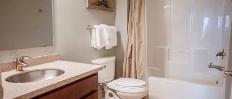 A bathroom with a sink, toilet, and bathtub.