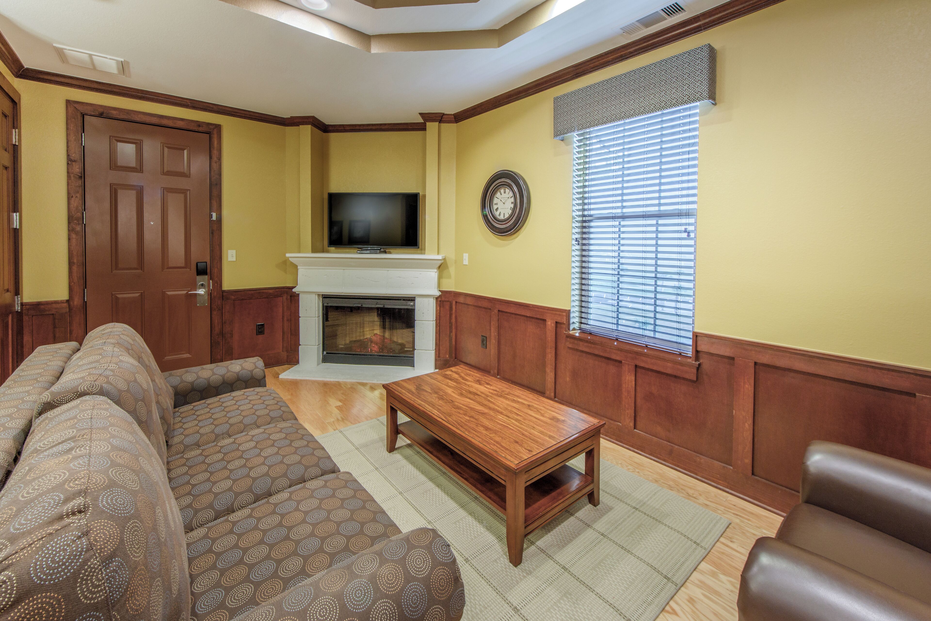 A living room with a fireplace, a television, and a sofa.
