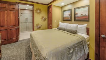 Una habitación de hotel con cama, ducha y dos cuadros en la pared.
