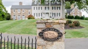 Uma placa de pedra com a inscrição 'The Inn at Evergreen' e o ano de fundação 'por volta de 1826' e 'estab. 1968'.