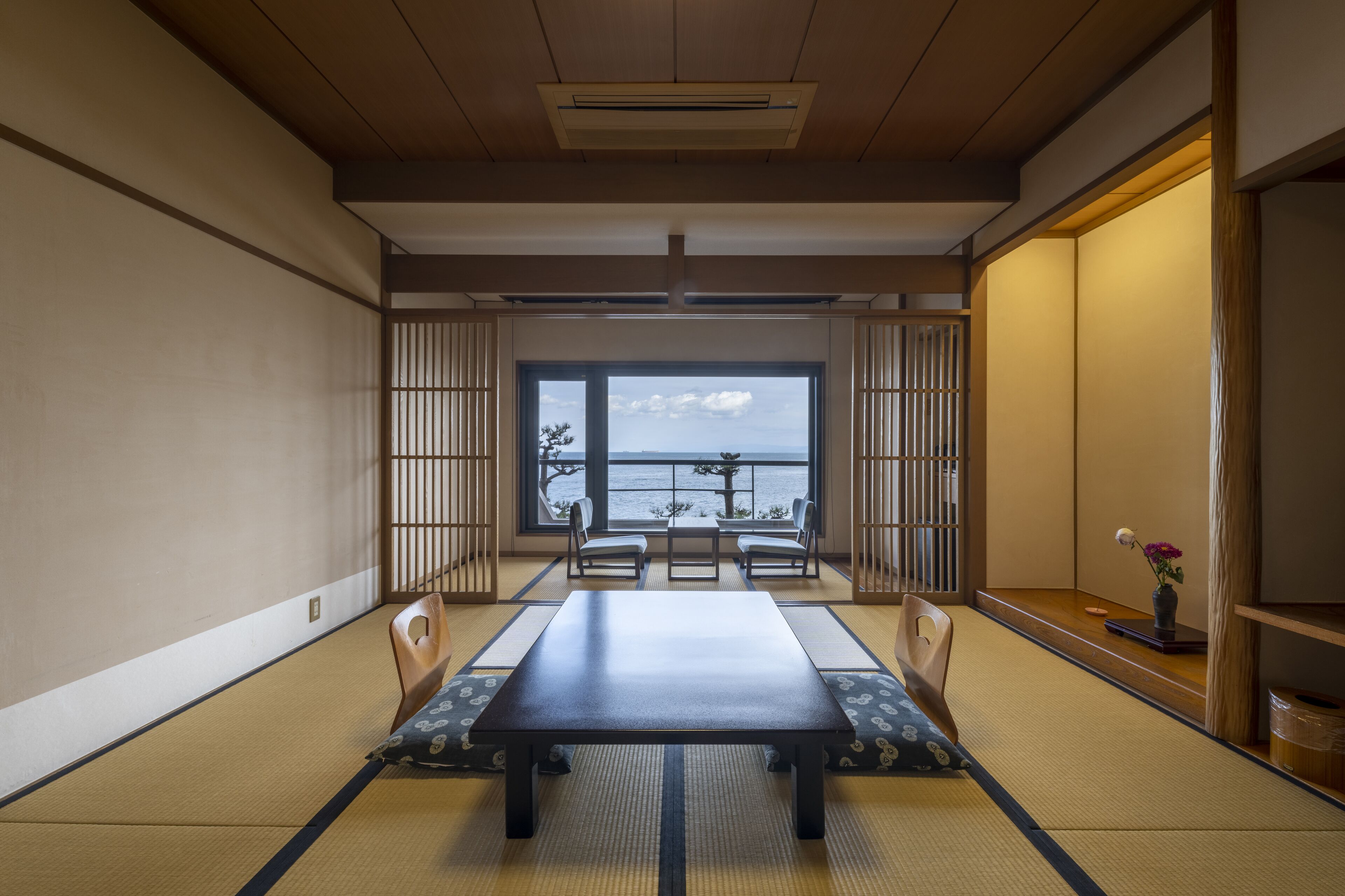 Una tradizionale stanza giapponese con pavimento in tatami, un tavolino basso e porte scorrevoli.