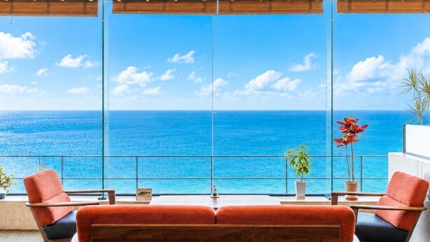 A balcony with a sofa and chairs, a view of the ocean, and potted plants. - Awakan (Sumoto)